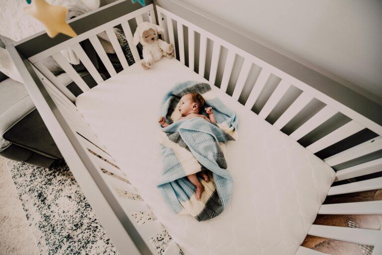 newborn baby sleeping in a crib